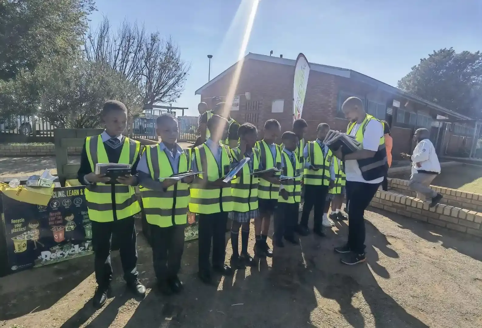 Workers in high-visibility uniforms sorting recyclables